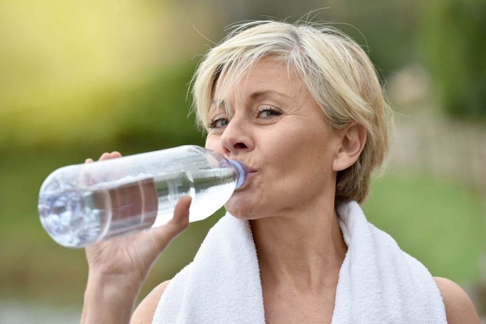 Stimolare il metabolismo donna che beve acqua e si idrata