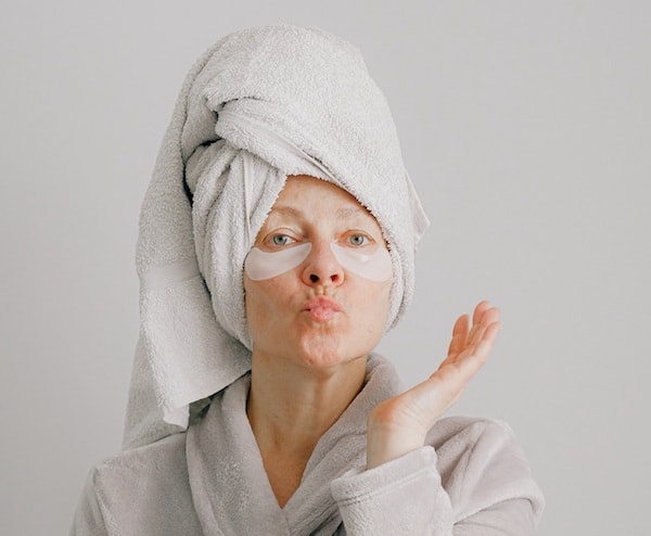 vitamine per la pelle donna adulta con asciugamano e accappatoio